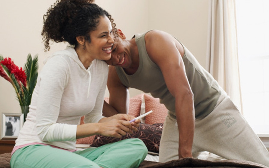 smiling couple with pregnancy test
